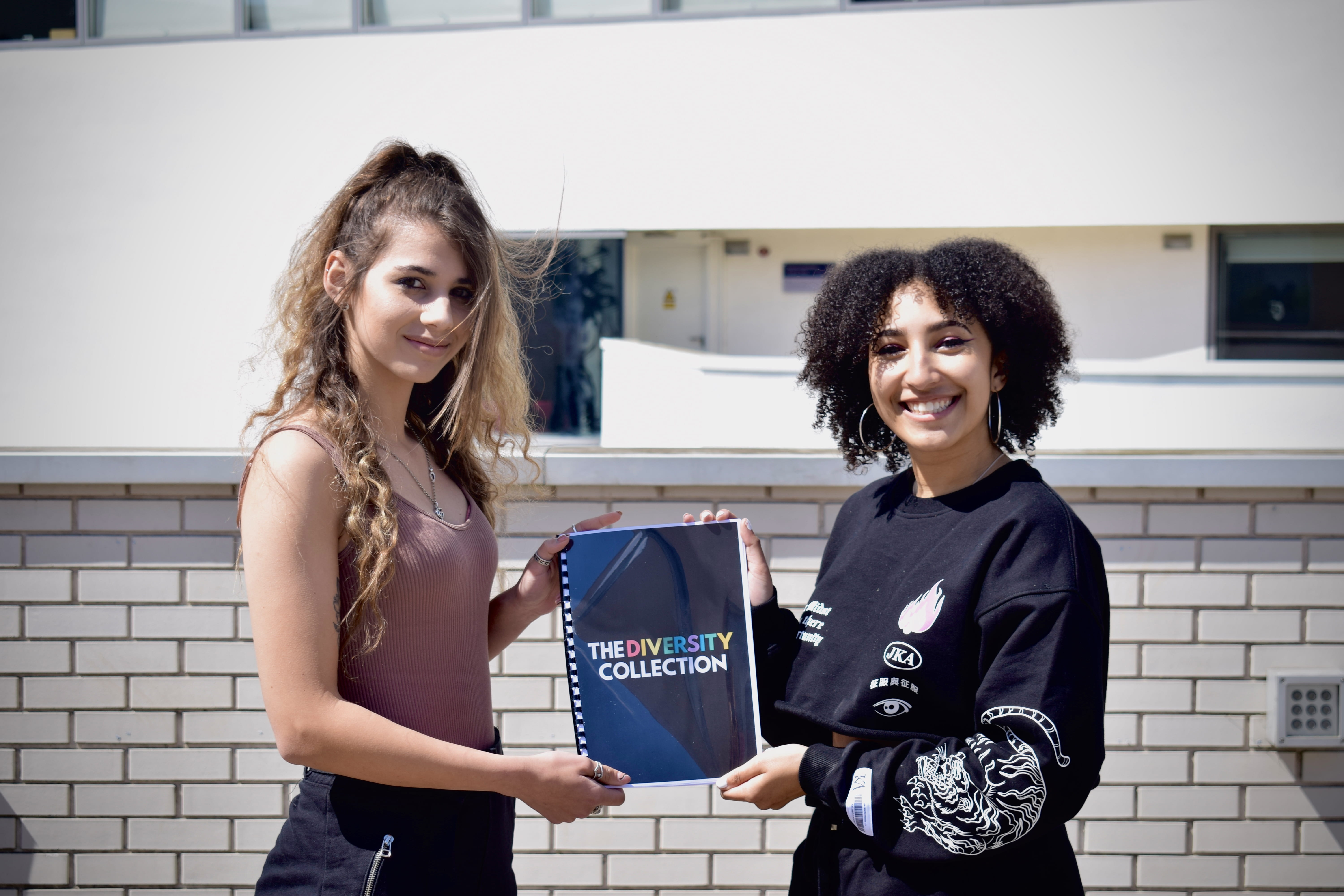 Image of Jas and Geo holding a printed edition of The Diversity Collection.