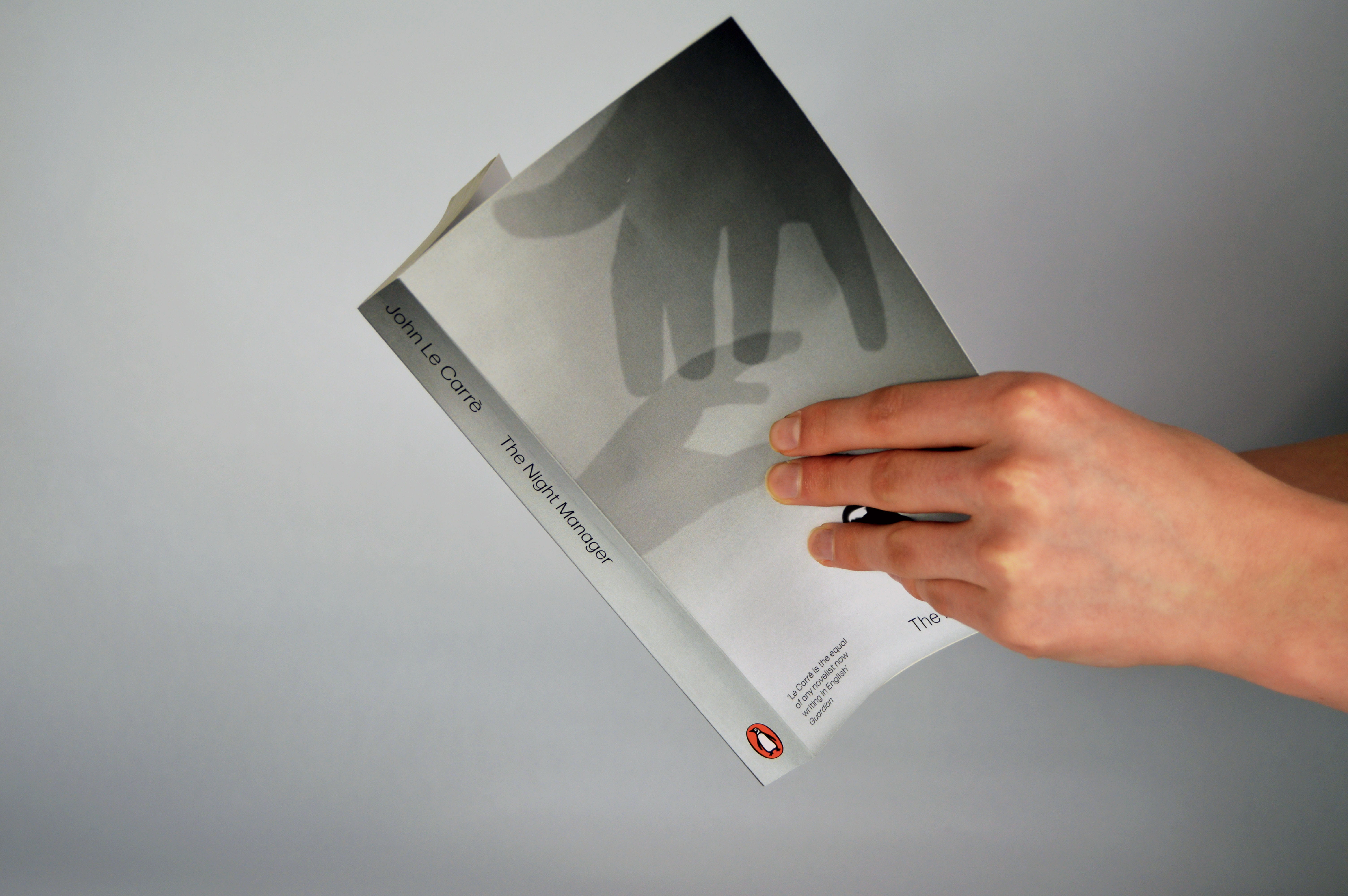 Book with front and spine visivle depicting the artwork of 2 hands reaching for the receptionists bell, and a spine matching the colour of the front cover background.