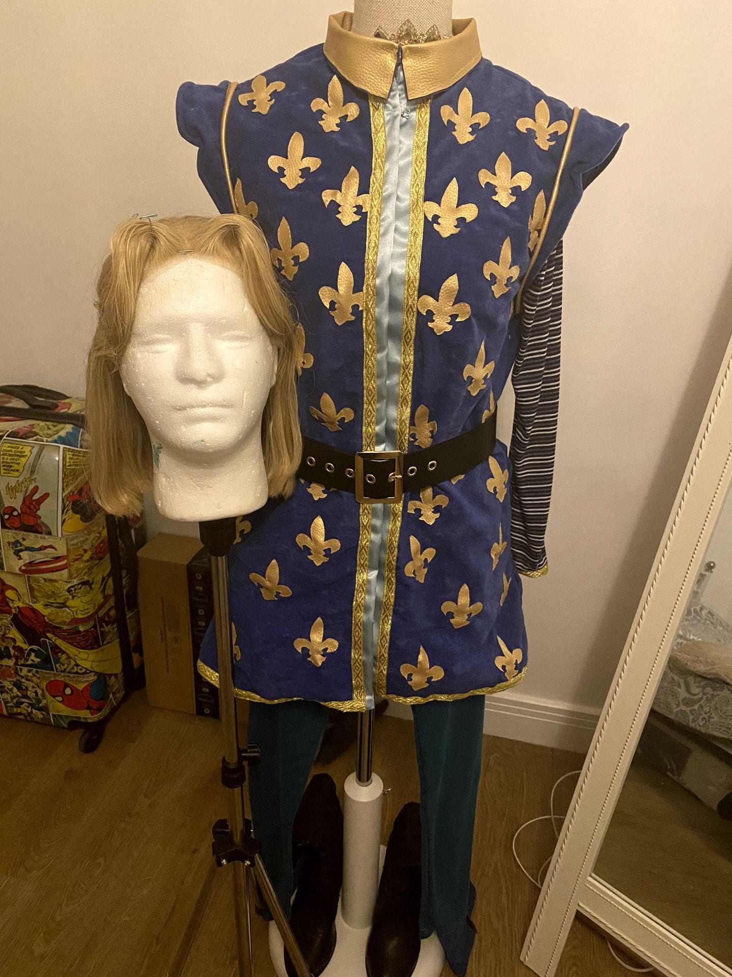 Full look at the price charming costume. Includes blonde wig, main blue bodice with gold detailing, blue leggings, black boots with a blue and gold trim and a black belt.