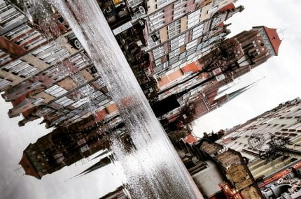 Photography of a city reflected in a puddle