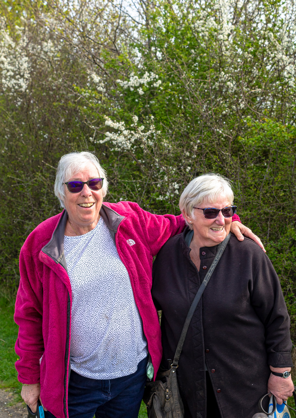 Two older people in a wooded area
