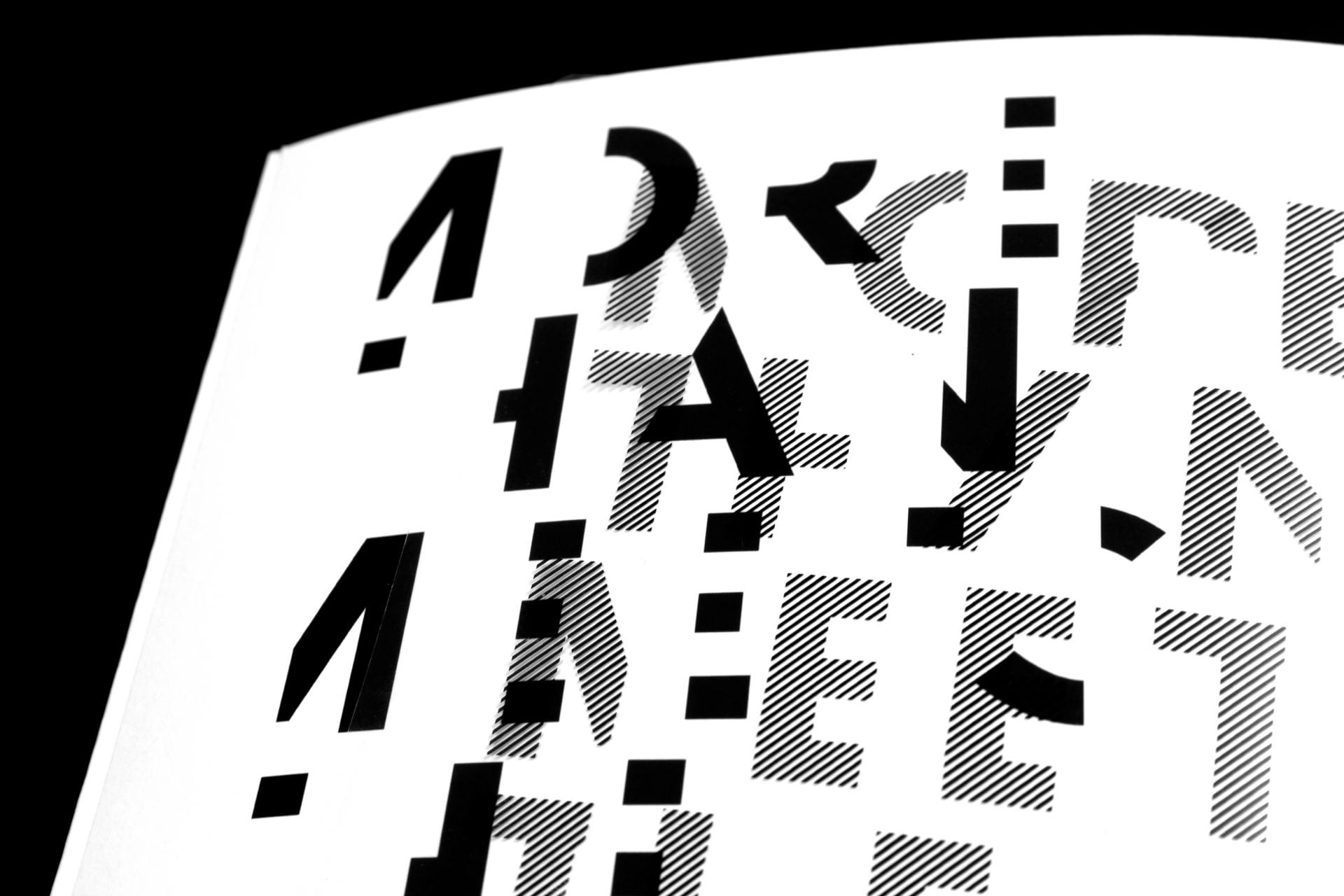 A selection of cut up letters, some black, some dotted, when put together it reads: 