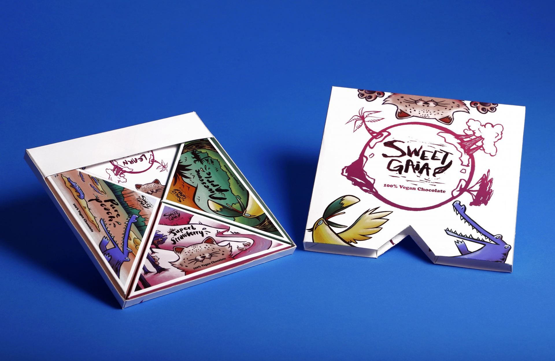 Packaging for a vegan chocolate brand called 'Sweet Gaia'. There is a tray that pulls out with three triangular chocolate wrappers inside. There are three mascots: a toucan, a leopard and a crocodile.