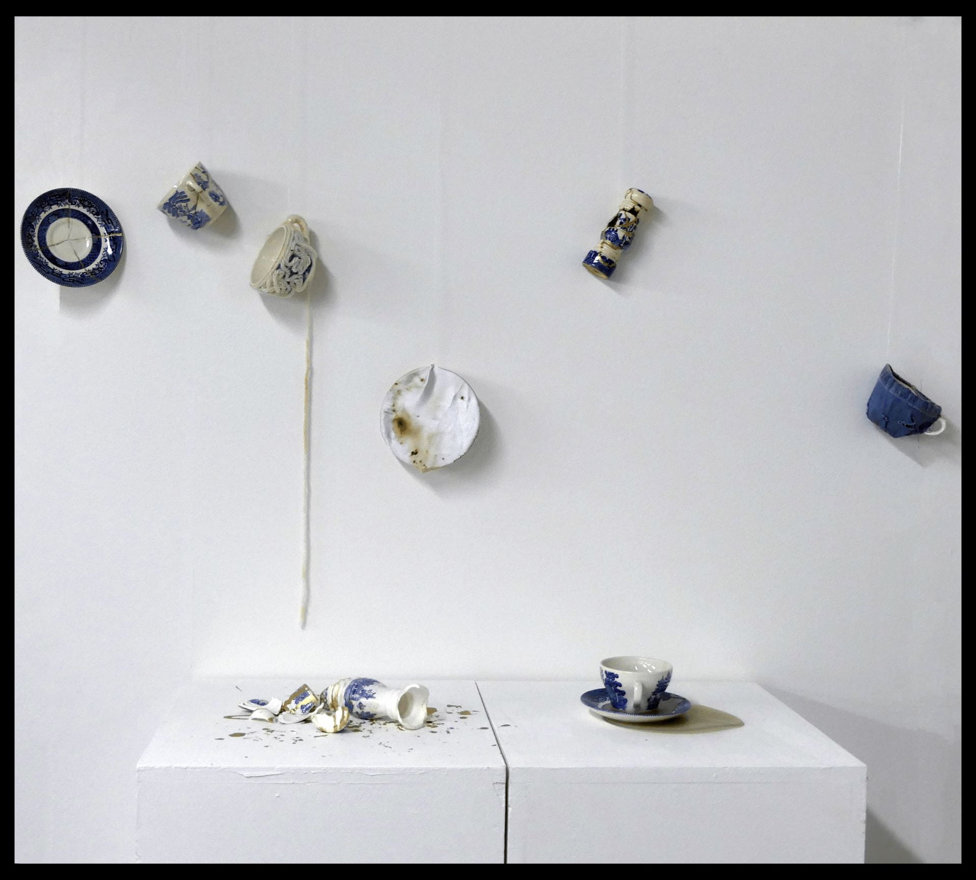 Artistic piece named 'Peace of Mind' a solo installation piece which explored control and the anxieties I experience when having no control over my environment, featuring blue and white crockery either smashed or in mid air.
