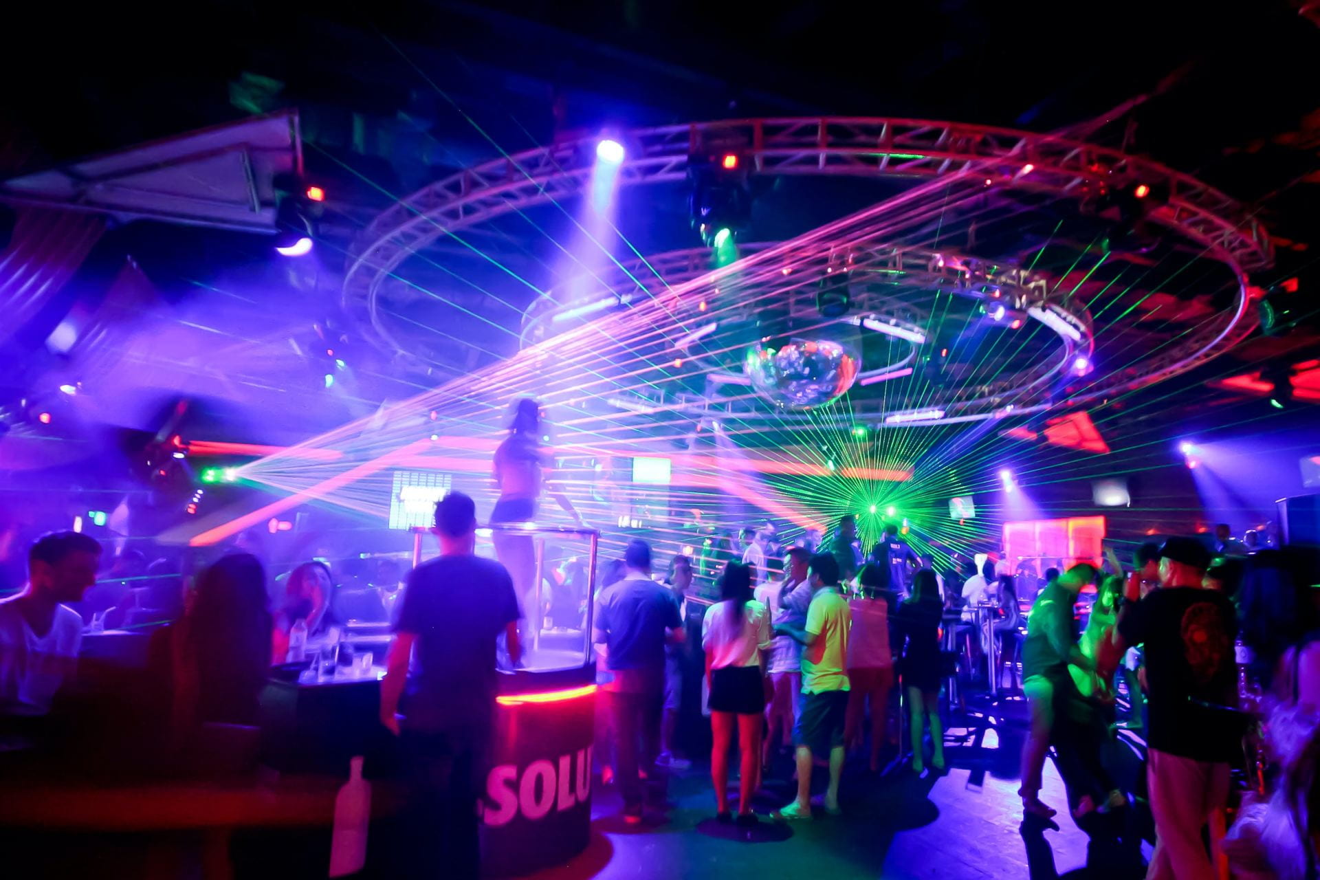 Crowded nightclub featuring strobe lights.