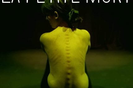 Photograph of naked women's back with the text 'la petite mort'