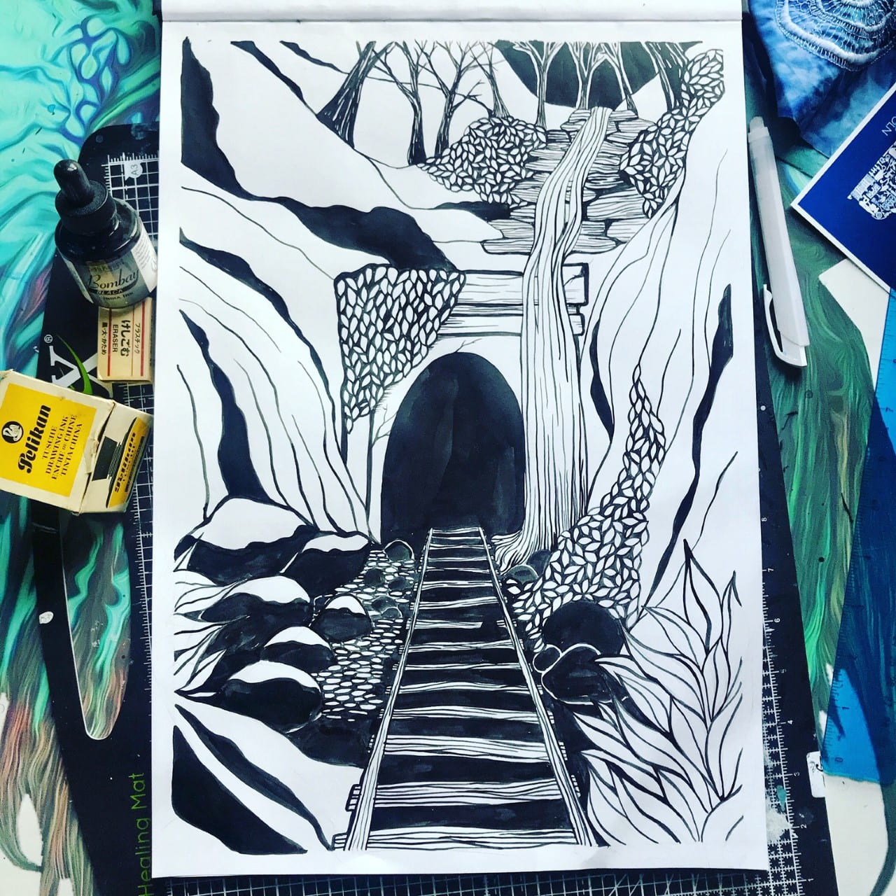Photograph of a Lino Print of an Abandoned Train Tunnel surrounded by art equipment.